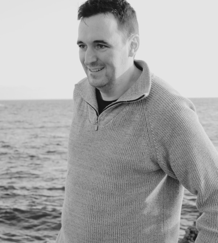 Travel designer Contrastes Homme brun quarantenaire mer en fond, souriant,