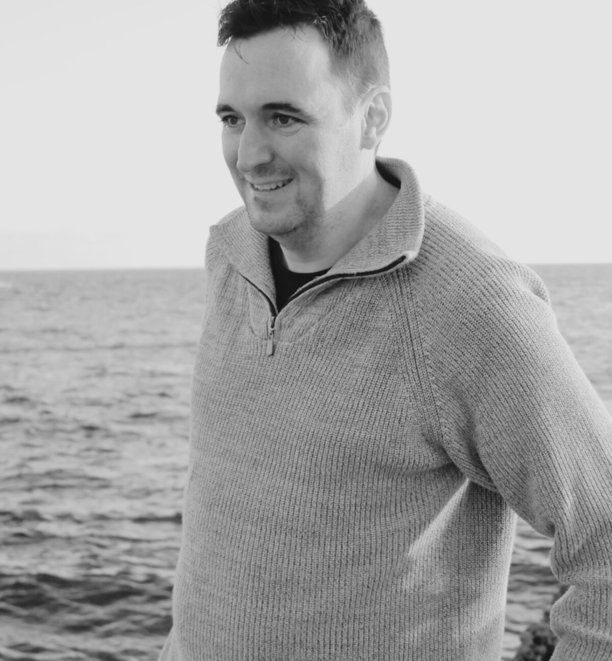 Travel designer Contrastes Homme brun quarantenaire mer en fond, souriant,