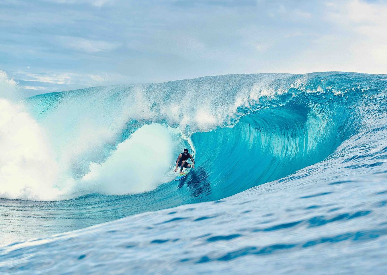 Surfeur dans la célèbre vague de Teahupo'o à Tahiti en Polynésie française.
