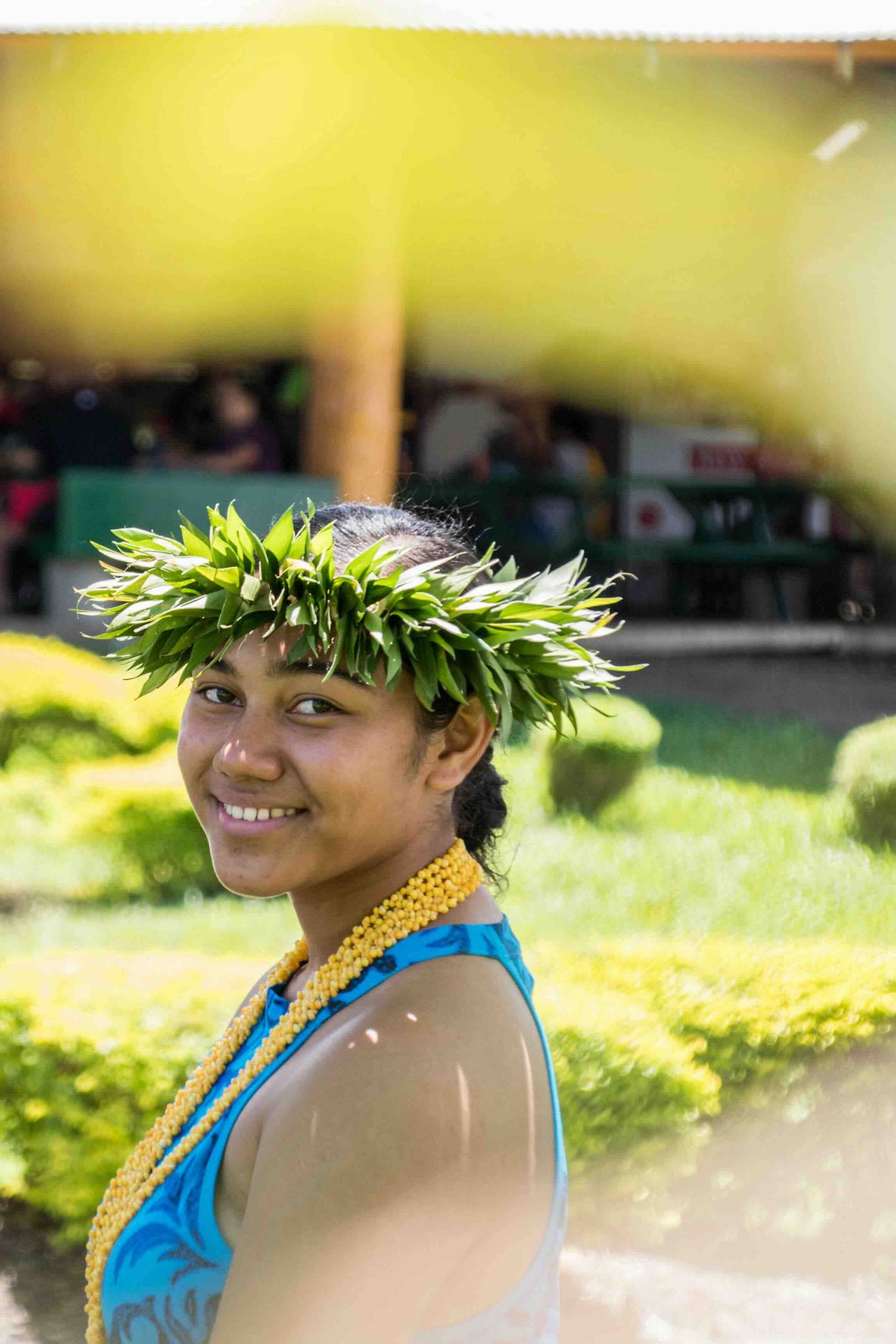 Jeune Polynésienne portant une couronne de feuilles traditionnelle en Polynésie française.