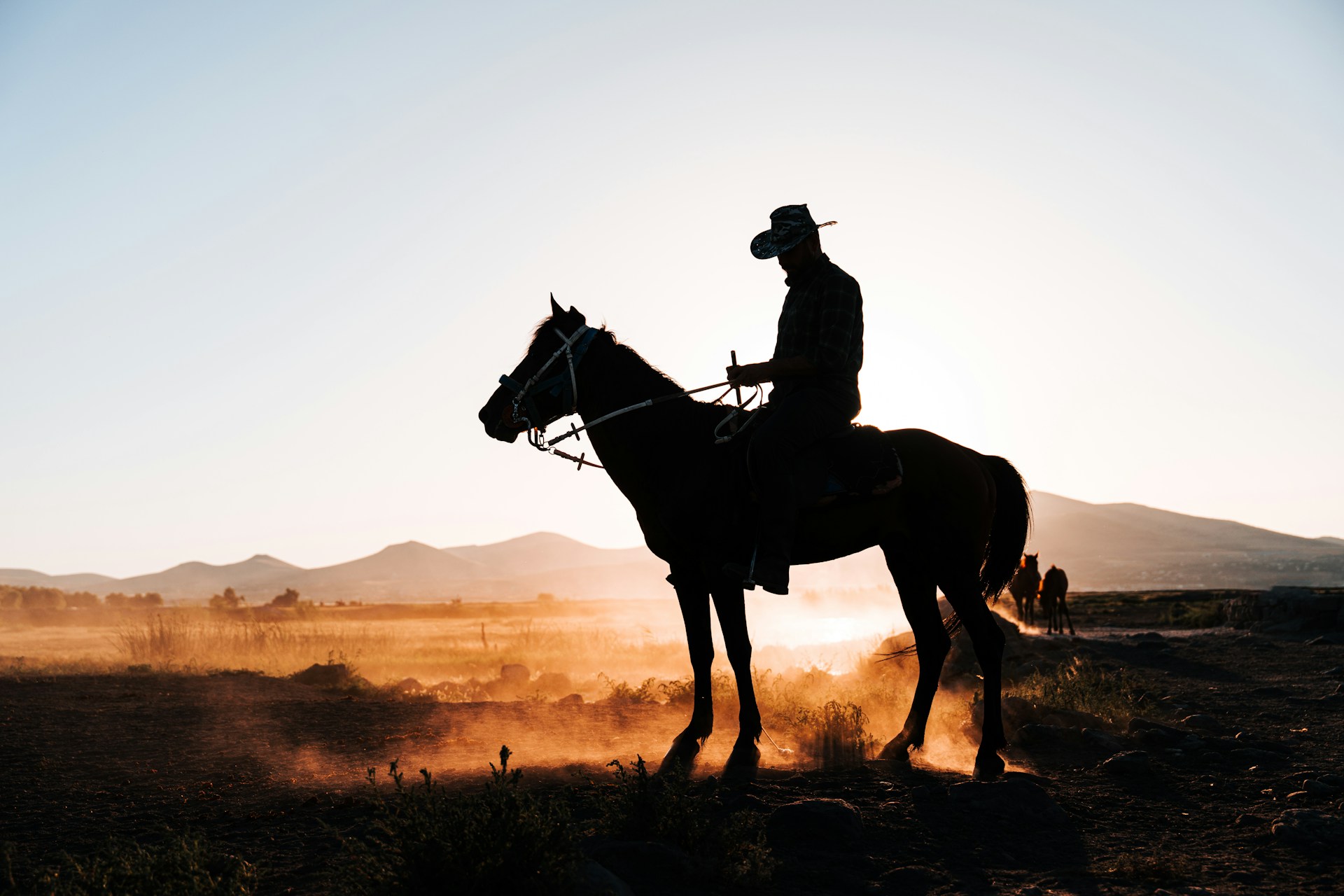 Cowboy à cheval au coucher du soleil dans les grands espaces de l’Alberta