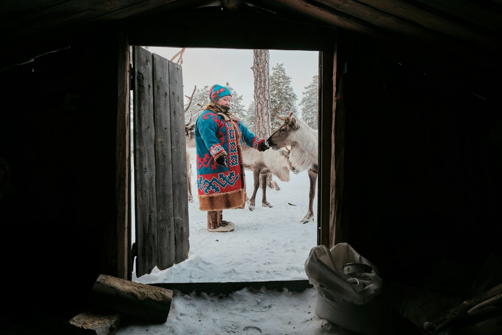 Rencontre avec une éleveuse de rennes en tenue traditionnelle dans un paysage enneigé de Laponie finlandaise.