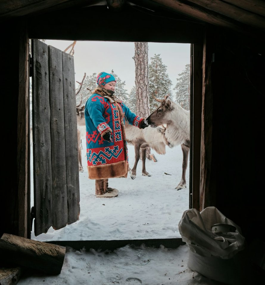 Rencontre avec une éleveuse de rennes en tenue traditionnelle dans un paysage enneigé de Laponie finlandaise.