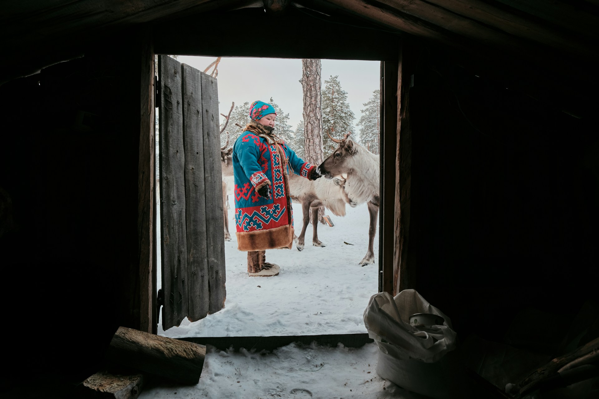Rencontre avec une éleveuse de rennes en tenue traditionnelle dans un paysage enneigé de Laponie finlandaise.
