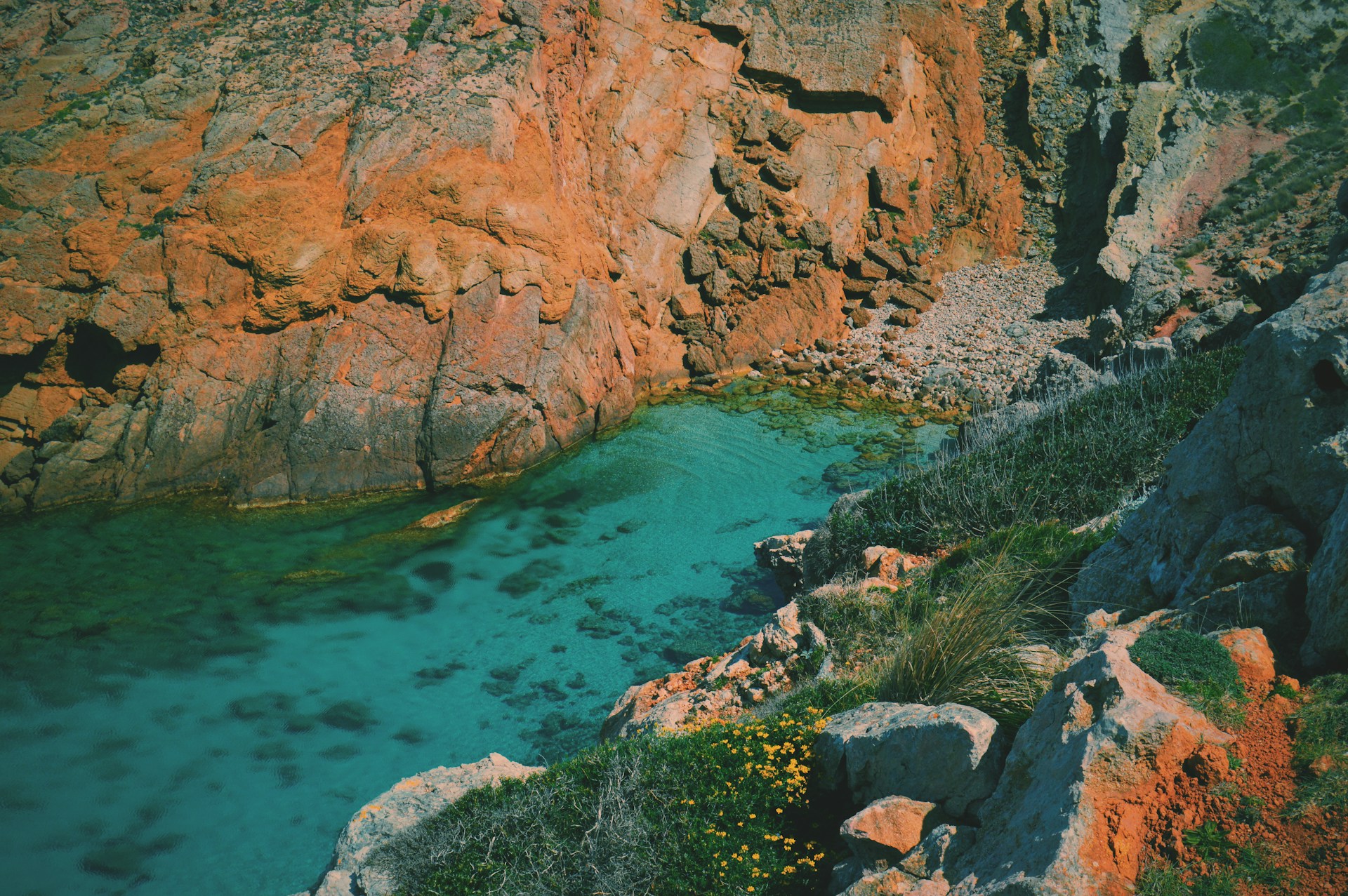 Crique sauvage aux eaux turquoise entourée de roches sur la côte de Minorque.