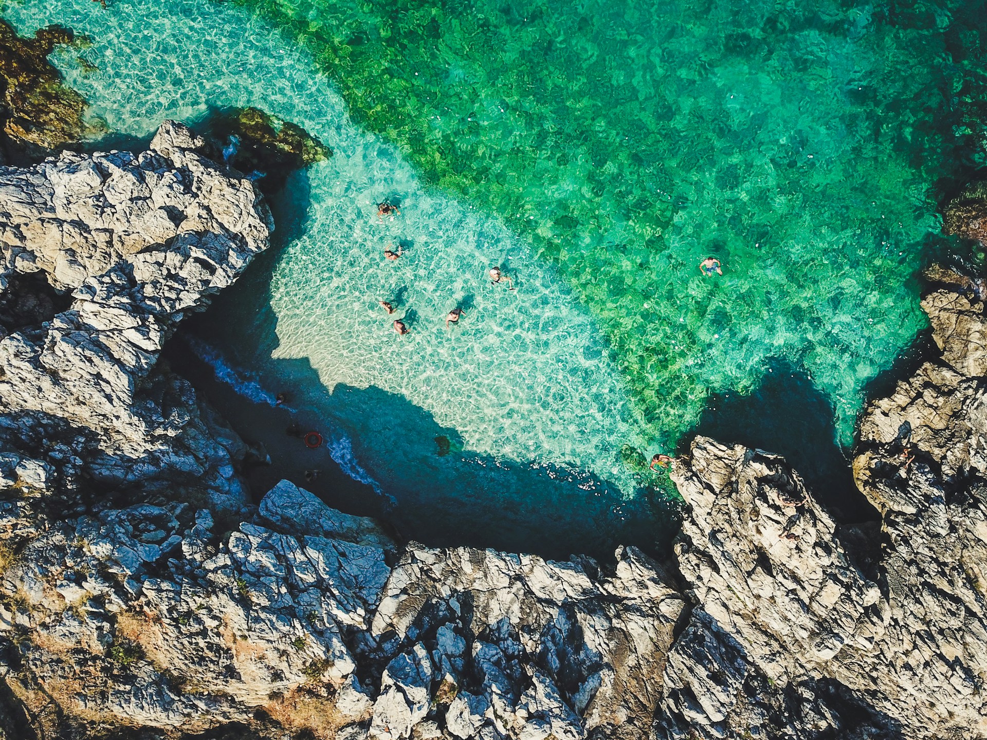 Baignade dans une crique aux eaux turquoise et cristallines en Sicile.