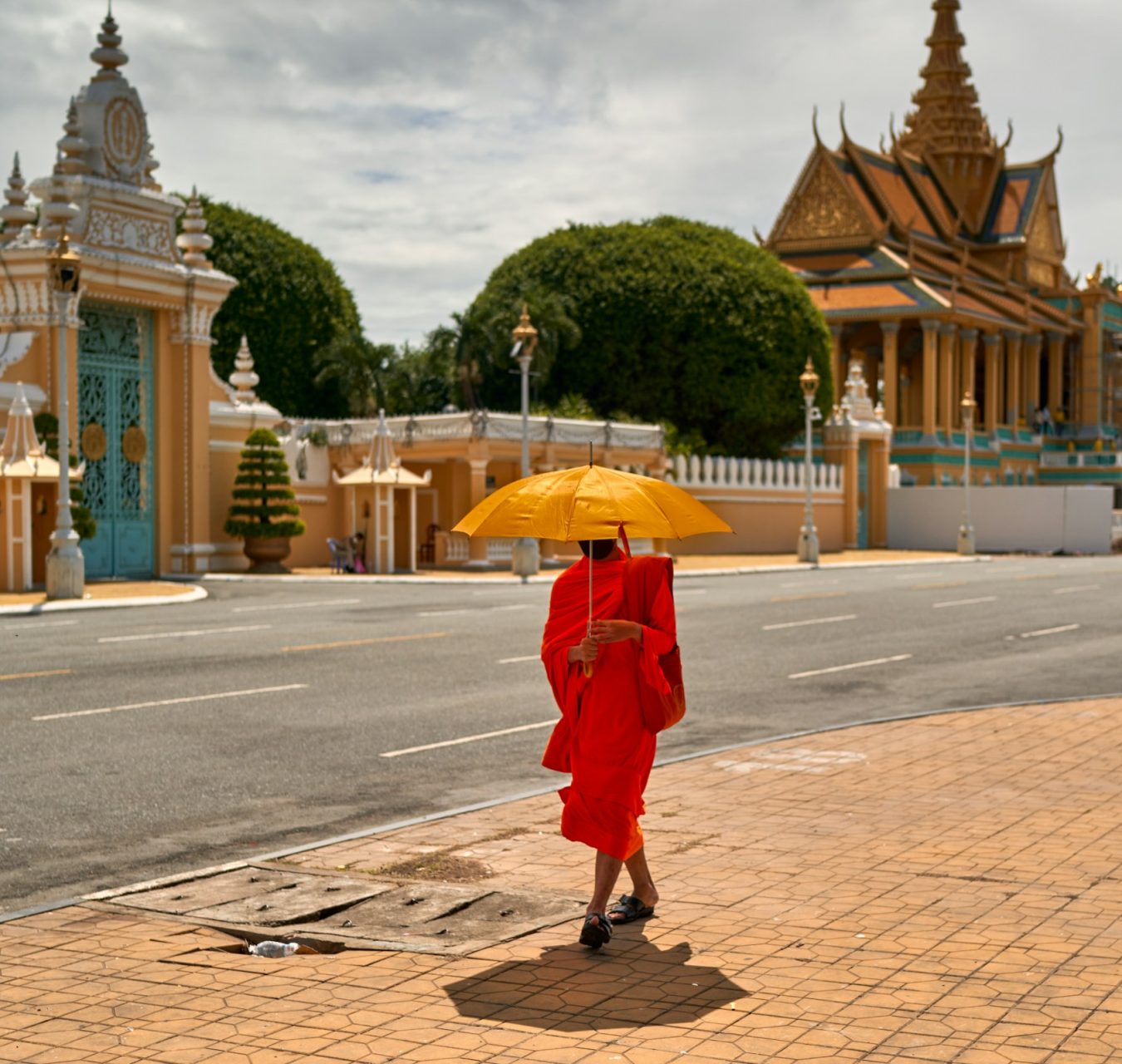 Moine bouddhiste en robe orange devant un temple au Cambodge