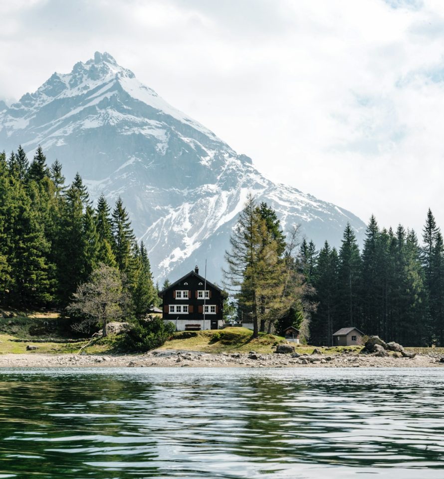 Chalet traditionnel au bord d’un lac entouré de montagnes dans les Alpes suisses