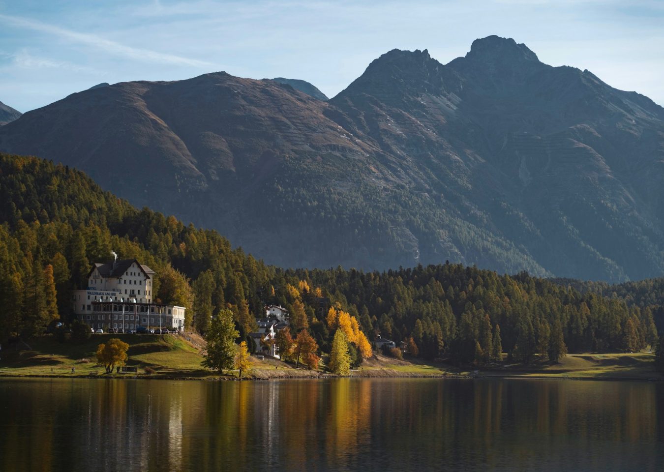 Lac alpin entouré de montagnes et de forêts aux couleurs d’automne en Suisse